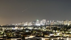 A streak of light illuminates the sky during an Iranian missile attack toward Israel as seen from the city of Ashkelon.