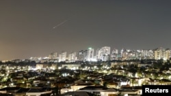 A streak of light illuminates the sky during an Iranian missile attack toward Israel as seen from the city of Ashkelon.