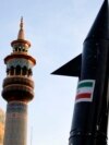 Iranski demonstranti nose model projektila dok se u pozadini vidi minaret i kupola džamije tokom antiizraelskog skupa u Teheranu 15. aprila.