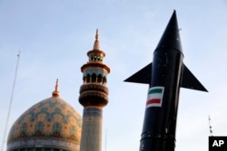 Модель іранської ракети проносять поруч з мечеттю в Тегерані. 15 квітня 2024 року