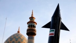 A model of a missile is carried by Iranian demonstrators as a minaret and dome of a mosque is seen in the background during an anti-Israeli rally in Tehran on April 15.