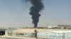 A large plume of smoke rises from the fuel  depot at King Khalid International Airport in Riyadh on September 19. (See item below.)