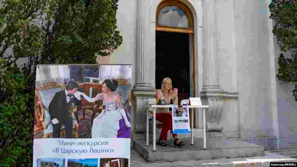 Дівчина-касир в очікуванні відвідувачів на порозі Лівадійського палацу-музею