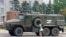 An elderly woman looks at an armored truck belonging to pro-Russian troops parked near Ukraine's former regional council building in the Russia-controlled city of Kherson on July 25.