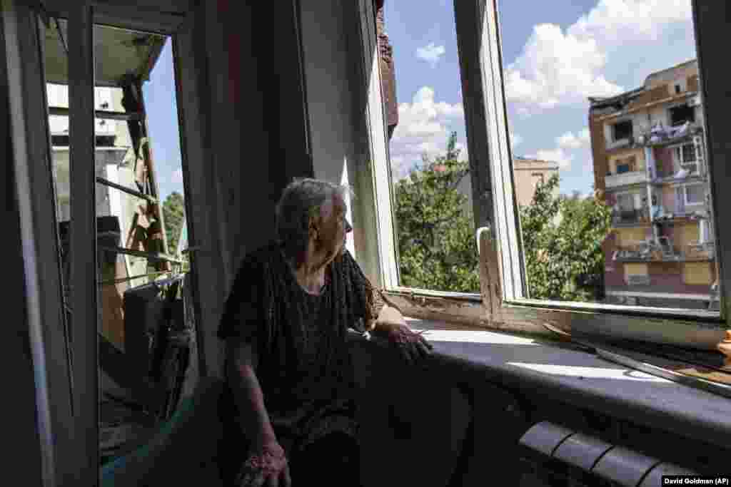 Ida Svystunova, 89, looks out a room adjoining her apartment that was damaged in a May rocket attack in Slovyansk in eastern Ukraine. Svystunova is one of only four people left living in the block and spends most of her day looking out the window. &quot;I sit and wait for the end of this war or maybe the end of ourselves,&quot; she said.