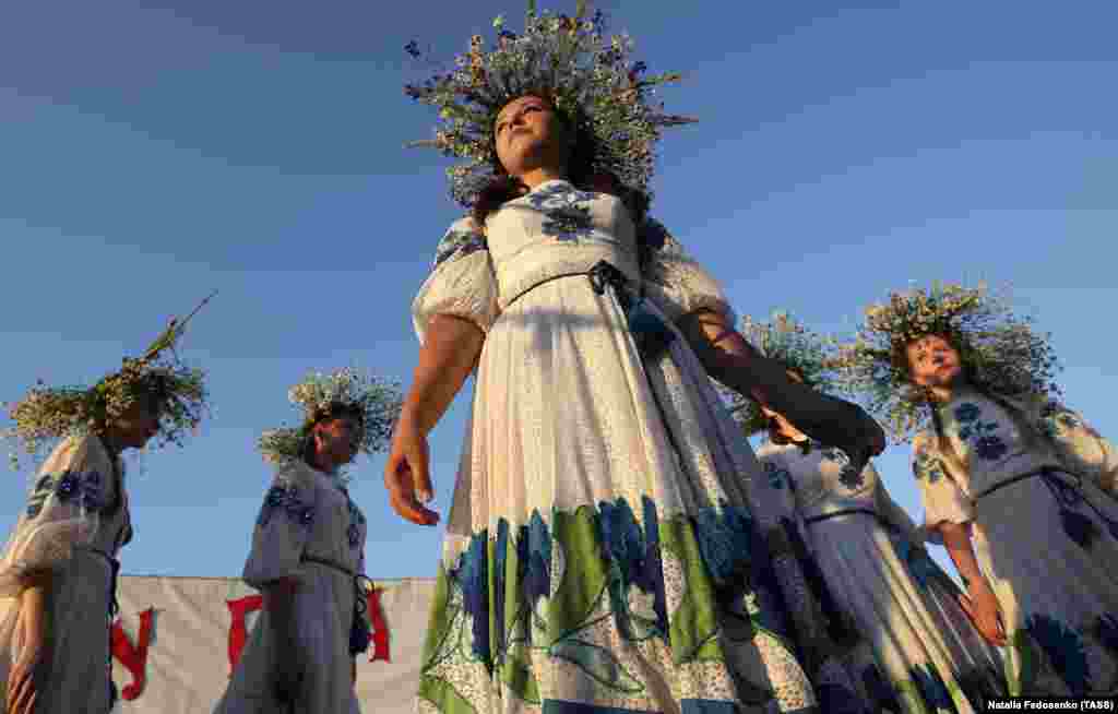 Girls wear ethnic costumes and flower wreaths.