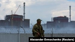 A soldier with a Russian flag on his uniform stands guard near the Zaporizhzhya nuclear power plant on August 4.