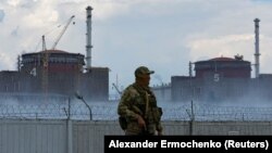 Військовий із російським прапором на формі стоїть біля Запорізької атомної електростанції, що неподалік міста Енергодару Запорізької області, 4 серпня 2022 року