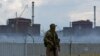 A soldier with a Russian flag on his uniform stands guard near the Zaporizhzhya nuclear power plant outside the Russian-controlled city of Enerhodar on August 4. 