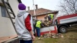 A közmunkásokat foglalkoztató Dehusz Kft. dolgozói tűzifát pakolnak egy rászoruló udvarán Debrecenben 2020. január 20-án