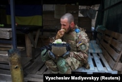 Një anëtar i Gardës Kombëtare të Ukrainës duke ngrënë një mollë në një pozicion pranë vijës së frontit në rajonin e Harkivit, mes sulmeve ruse në Ukrainë, 3 gusht 2022.