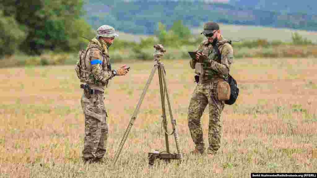 Ukrainian military personnel check their coordinates before firing.