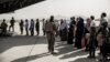 Evacuees wait to board a plane during an evacuation at Hamid Karzai International Airport in Kabul in August 2021. 