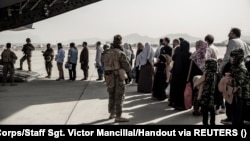 Evacuees wait to board a plane during an evacuation at Hamid Karzai International Airport in Kabul in August 2021. 