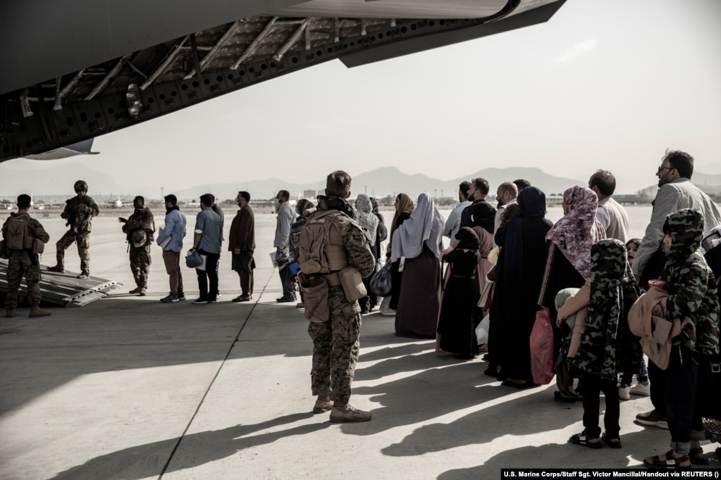 Evacuees wait to board a Boeing C-17 Globemaster III during an evacuation at Kabul Airport on August 30, 2021.