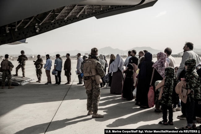 Të evakuuarit derisa presin të hipin në një Boeing C-17 Globemaster III gjatë evakuimit në Aeroportin e Kabulit më 30 gusht 2021.