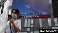 Трансляция военных учений на уличном экране в Пекине