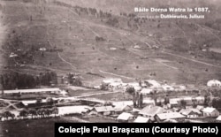 Vatra Dornei în 1887, colecția lui Paul Brașcanu. În stânga, băile de la acea vreme. Cazinoul urma să fie construit în dreapta, peste râu. Pădurile care domină acum versantul din față fuseseră exploatate. Versantul golaș e o surpriză pentru cei obișnuiți cu peisajul contemporan, în care acolo există o pârtie, dar și mulți brazi.