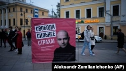 People walk past an election poster with a portrait of Andrei Pivovarov with the words "Freedom is stronger than fear!" in Moscow on September 7.