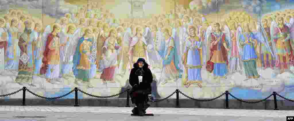Një grua e moshuar kërkon lëmoshë jashtë Manastirit Saint Michael në Kiev, Ukrainë.&nbsp;