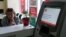 An employee sits next to a payment terminal out of order at a branch of Ukraine's state-owned Oschadbank in Kyiv on June 27.