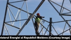 Muncitor pe un pilon al liniei electrice de înaltă tensiune Vulcănești-Chișinău, în timpul construcției
