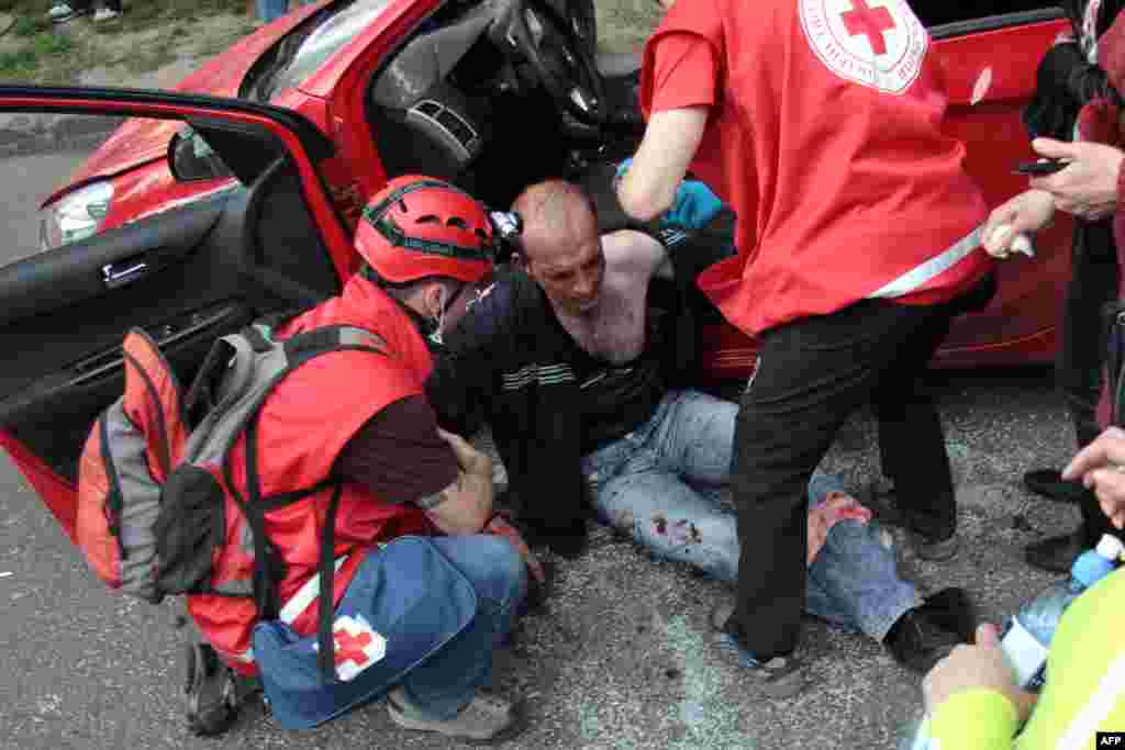 Медики допомагають пораненому у сутичці футбольних фанів із проросійськими радикалами, яка сталась після матчу &laquo;Металіст&raquo; - &laquo;Дніпро&raquo; у Харкові, 27 квітня 2014 року