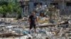Një banor vendas ecën midis mbetjeve të ndërtesave të banimit të shkatërruara nga një sulm me raketa ruse, ndërsa sulmi i Rusisë ndaj Ukrainës vazhdon, në vendbanimin Zatoka, rajoni Odesa, Ukrainë, 26 korrik 2022.