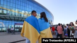 Tineri cu steaguri ucrainene în fața sălii de concerte Almaty Arena, Almatî, 31 iulie 2022