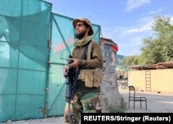 A Taliban fighter stands guard near the site where Zawahiri was killed in a U.S. strike in Kabul.