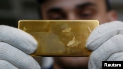 An employee shows a gold bar at a plant in Kasimov, Russia.