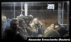 Военнослужащие ВСУ, сдавшиеся в плен на осажденном меткомбинате «Азовсталь» в Мариуполе, в сопровождении российских военных прибывают на автобусе в поселок Оленовка в Донецкой области для последующего обмена, 20 мая 2022 года