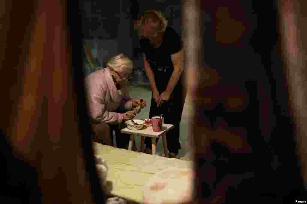 A 92 éves Marija Nyikolajevna az alagsorban ebédel, 58 éves lánya, Natalja áll mellette. Mivel mindkét otthonuk lakhatatlanná vált, a család egy barátjuk lakóházának pincéjében él