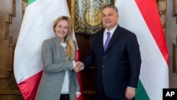 Președinta partidului Fratelli d’Italia, Giorgia Meloni, dă mâna cu premierul ungar Viktor Orbán în timpul întâlnirii care a avut loc în Parlamentul din Budapesta, Ungaria, pe 28 februarie 2018.