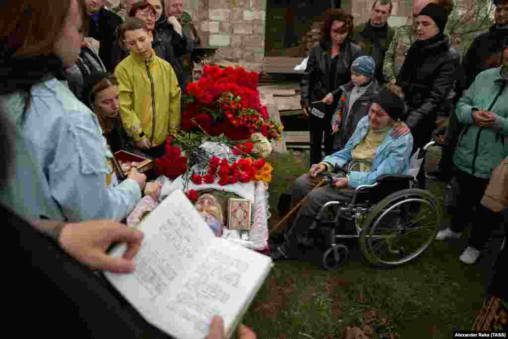 Мать Михаила Кищика (она сидит в инвалидной коляске) смотрит на тело своего сына в день его похорон в Луганской области Украины. Населенный пункт расположен на контролируемой прокремлевскими сепаратистами территории. Кищик, как сообщалось, работал в &laquo;народной милиции&raquo; сепаратистской&nbsp;&laquo;республики&raquo; &nbsp;