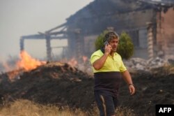 Lángoló épület a spanyolországi Pumarejóban 2022. július 18-án. A hatóságok több erdőtűzzel is küzdöttek a rendkívüli hőhullámban, amelynek következtében a hőmérséklet a 43 Celsius-fokot is elérte