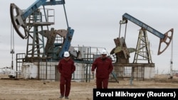 Workers walk near oil pumps at the Uzen oil and gas field in the Mangistau region of Kazakhstan. (file photo)