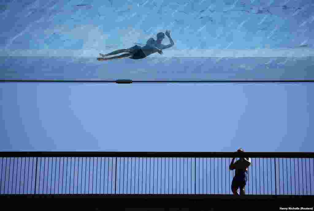 Osoba u Embassy Gardens Sky Poolu, providnom akrilnom bazenu između stambenih zgrada, tokom vrućeg vremena u Londonu, Velika Britanija, 10. juli.