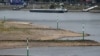 Teretnjak plovi Rajnom u blizini djelimično presušenog korita rijeke u Dizeldorfu, 25. jula 2022.