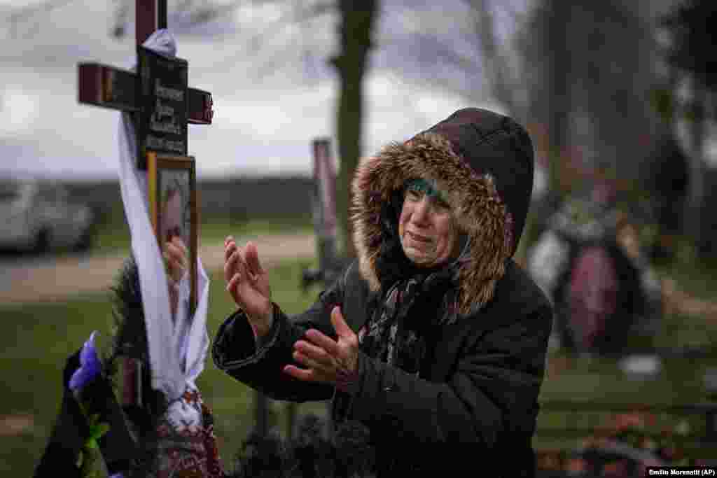 77-летняя Валентина Нечипоренко плачет на могиле сына Руслана во время его похорон в Буче 18 апреля 2022 года.