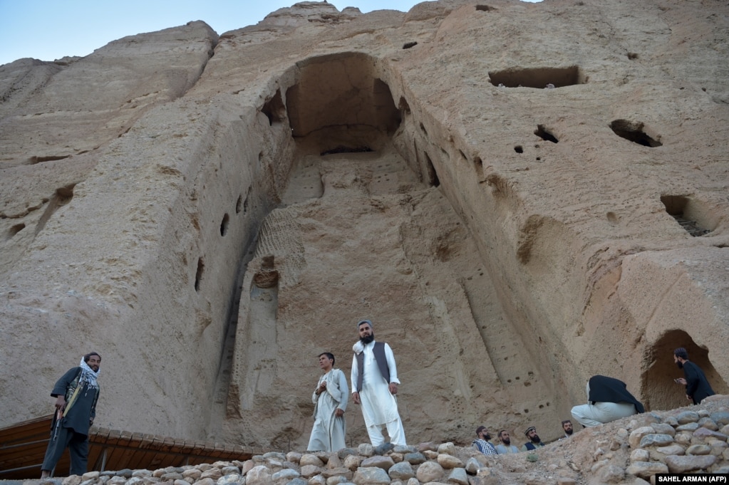 Taliban militants stand guard in front of the site where the Shahmama Buddha statue once stood before being destroyed by the Taliban in March 2001 in the central Bamiyan Province.