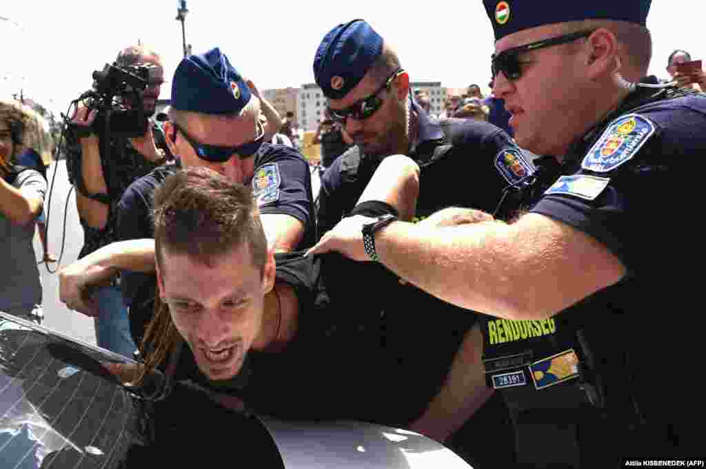 Hungarian police arrest a demonstrator on July 12 as several hundred protesters blocked Margaret Bridge (Margit Bridge), one of the most frequented bridges of the Hungarian capital, to protest against the Orban government&#39;s proposed amendment to taxation legislation. The amendment is expected to be approved in parliament, although small entrepreneurs -- already struggling with inflation -- say it will drastically increase their tax burden.