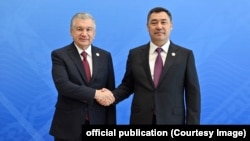 Uzbek President Shavkat Mirziyoev and Kyrgyz President Sadyr Japarov shake hands at a summit in July 2022.