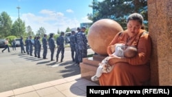 Police line up to prevent demonstrators from entering the presidential palace in Nur-Sultan on July 13. The protesters included a woman from Almaty who lost her husband in January carrying a 4-month-old baby.

