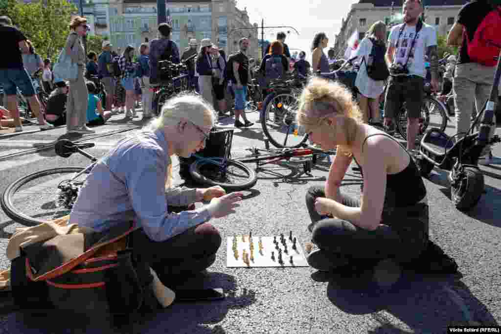 Bike couriers play chess and block traffic on Budapest&#39;s Margit Bridge on July 18 as they protest changes to a simplified tax regime known as KATA. Critics said the changes would hurt small businesses and affect hundreds of thousands of people. (Voros Szilard, RFE/RL)