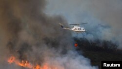 Un elicopter lucrează la stingerea unui incendiu în timpul celui de-al doilea val de căldură al anului în vecinătatea Guadapero, Spania, 15 iulie 2022 (Foto - Reuters/ Susana Vera)