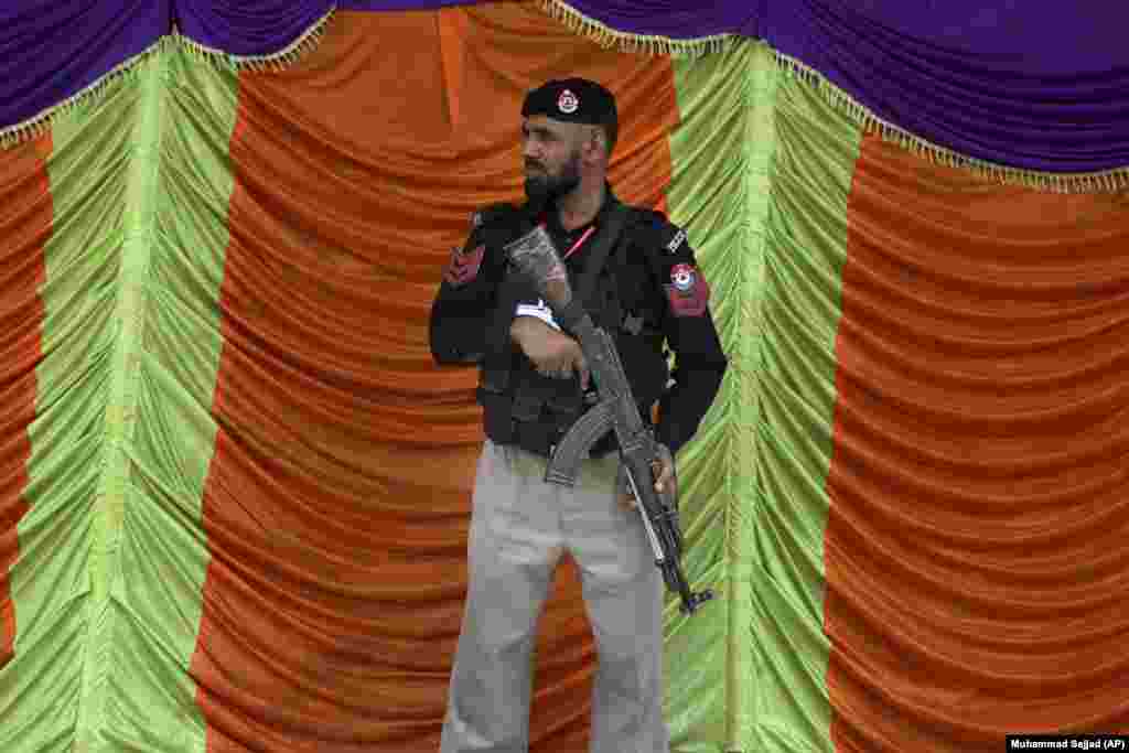 A police officer stands guard at a cordoned-off street to ensure security on the route of Shi&#39;ite Muslim&#39;s Muharram procession in Peshawar, Pakistan. Muharram, the first month of the Islamic calendar, is a month of mourning for Shi&#39;ites in remembrance of the death of Hussein, the grandson of the Prophet Muhammad, at the Battle of Karbala in present-day Iraq in the seventh century.