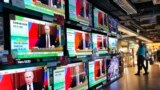 People stand by TV screens broadcasting the news of Russian invasion of Ukraine, in Hong Kong, Feb. 24, 2022. (AP/Vincent Yu)