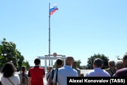 Жители во время поднятия флага России на центральной площади оккупированного Мелитополя. Украина, 12 июня 2022 год