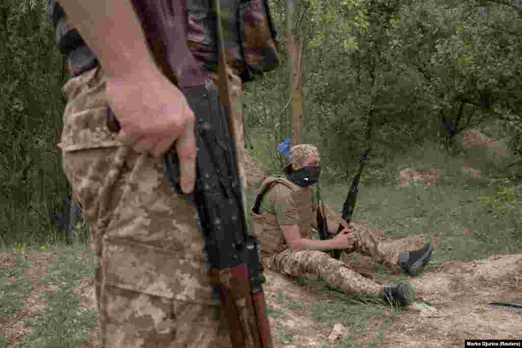 Soldiers take a break during training. Members of nationalist units like the Carpathian Sich have been integrated into Ukraine&#39;s armed forces, where they are eligible for pensions and treatment at military hospitals.